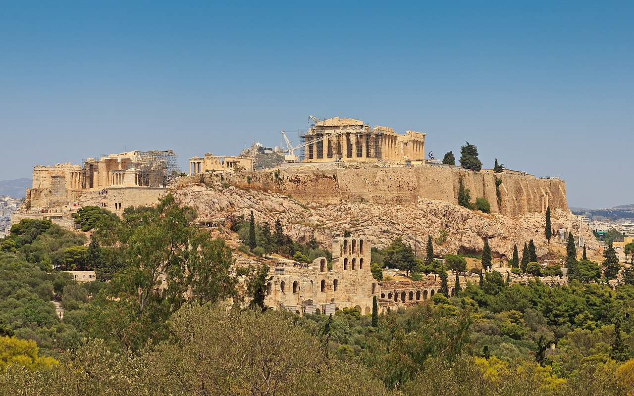 The Acropolis of Athens with the Parthenon above the rocky hill and trees, viewed from Philopappos Hill