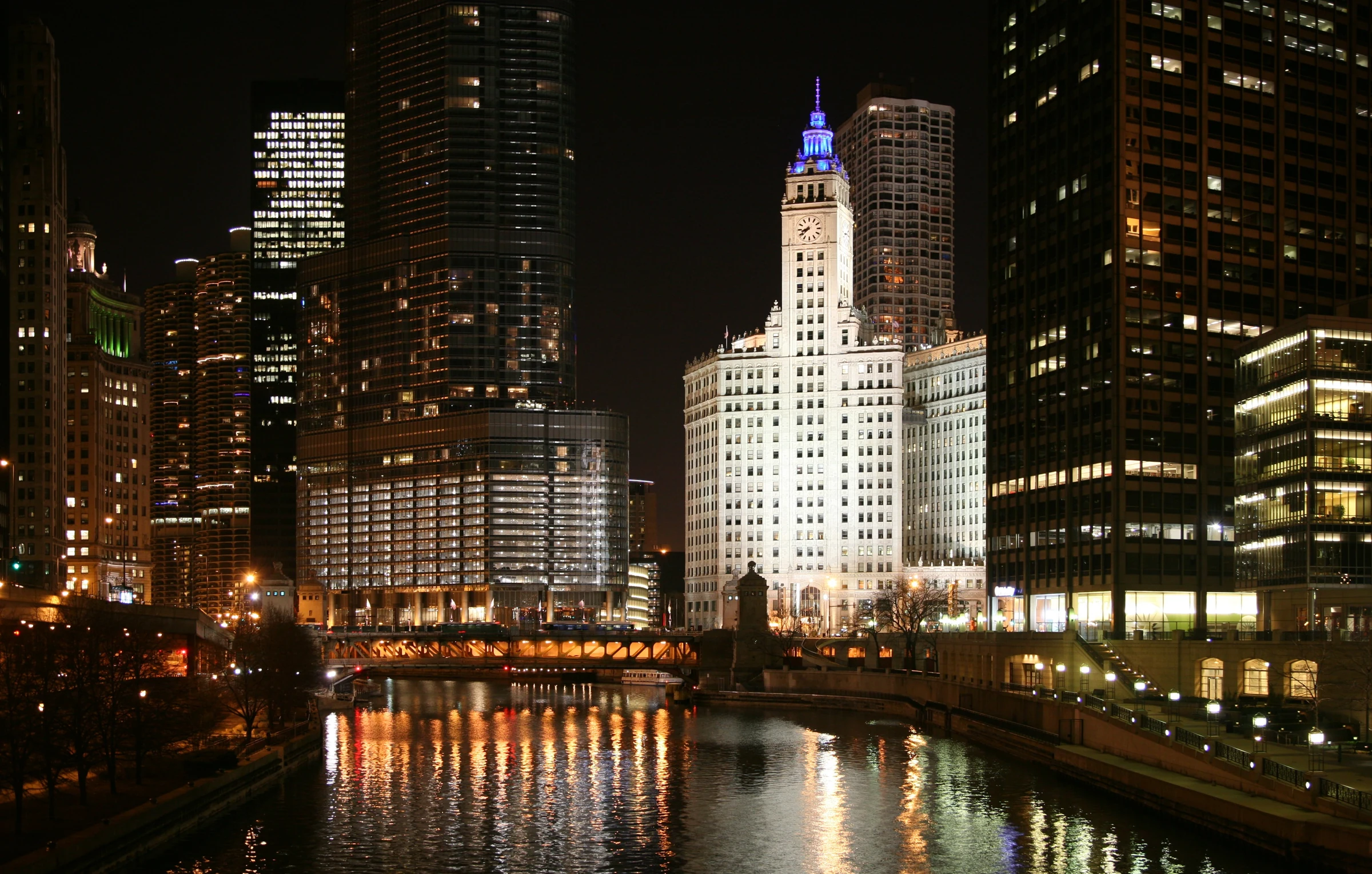 Chicago River and illuminated towers with a bridge and reflections at night