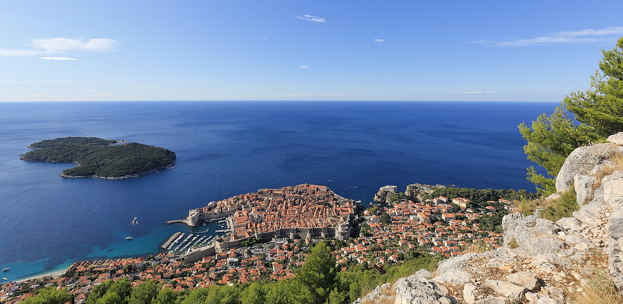 Dubrovnik Old Town walls and terracotta roofs beside the blue Adriatic, viewed from the hillside