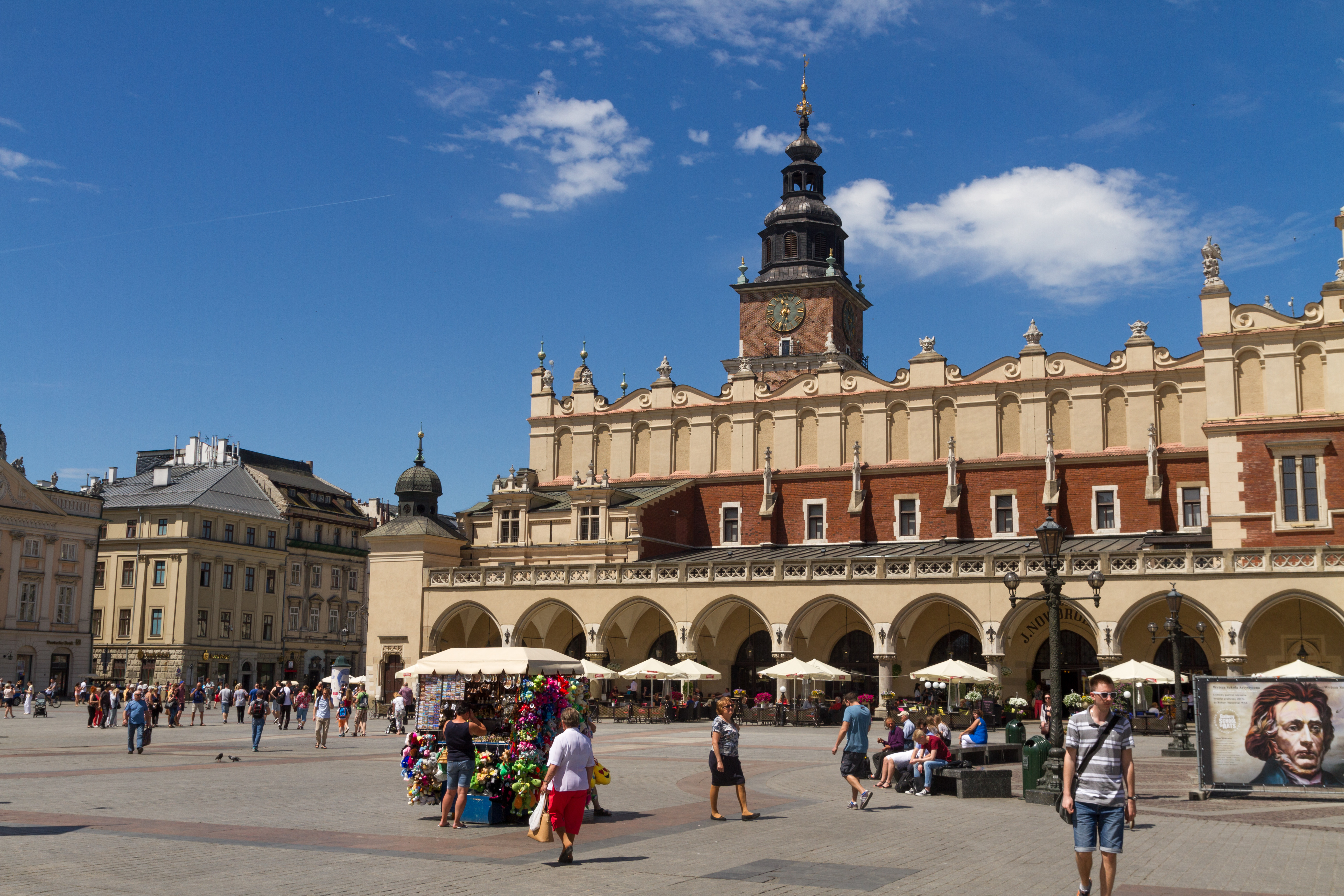 The Cloth Hall and Town Hall Tower beside people in Krakow Main Square