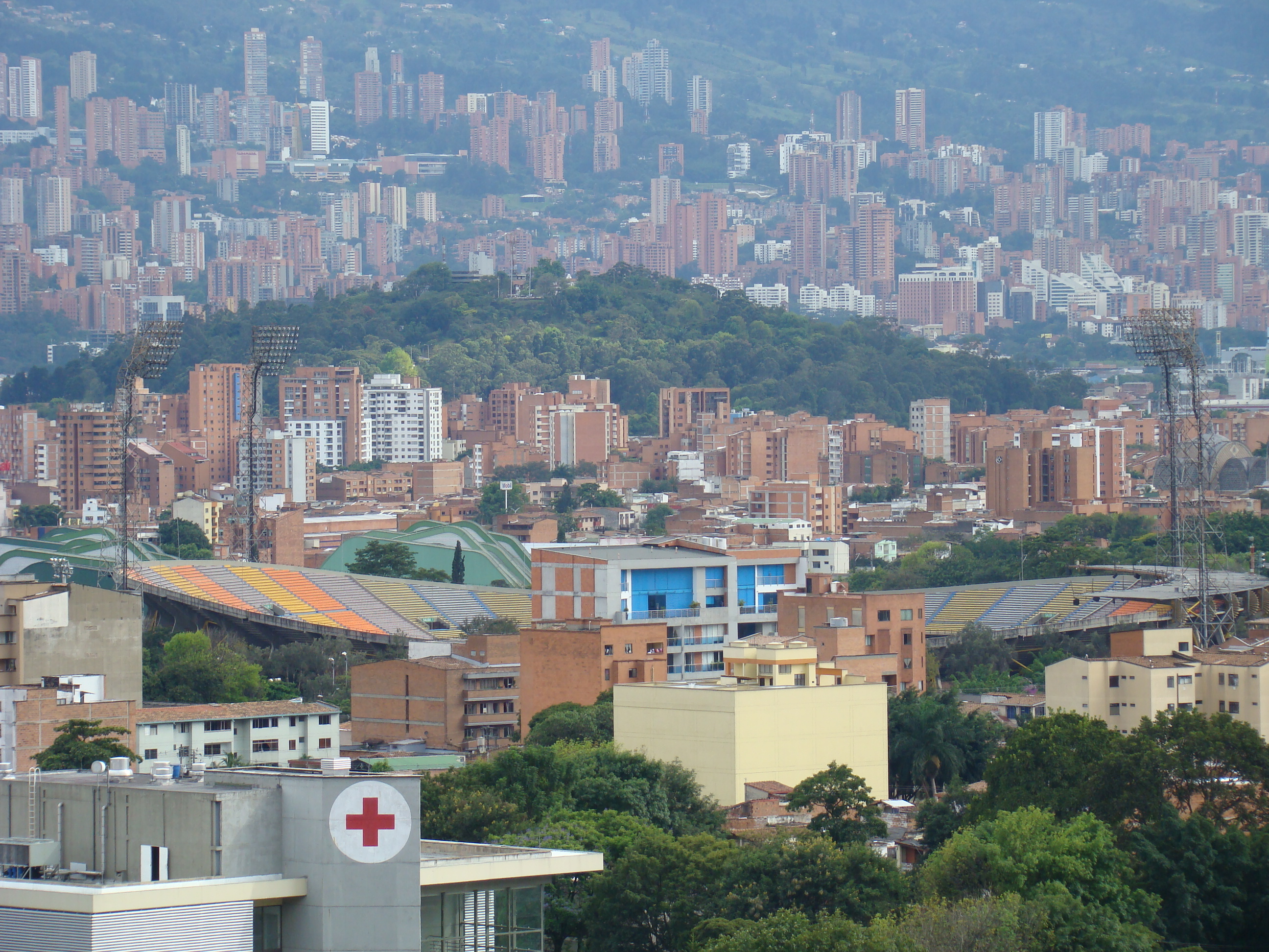 Historic Medellin skyline with hillside buildings, trees and stadium stands