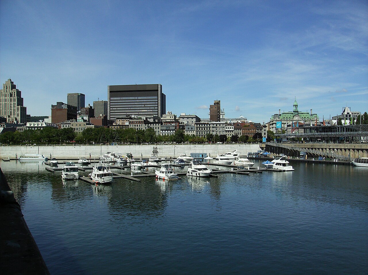Boats and quays in the Old Port of Montréal with the city skyline behind