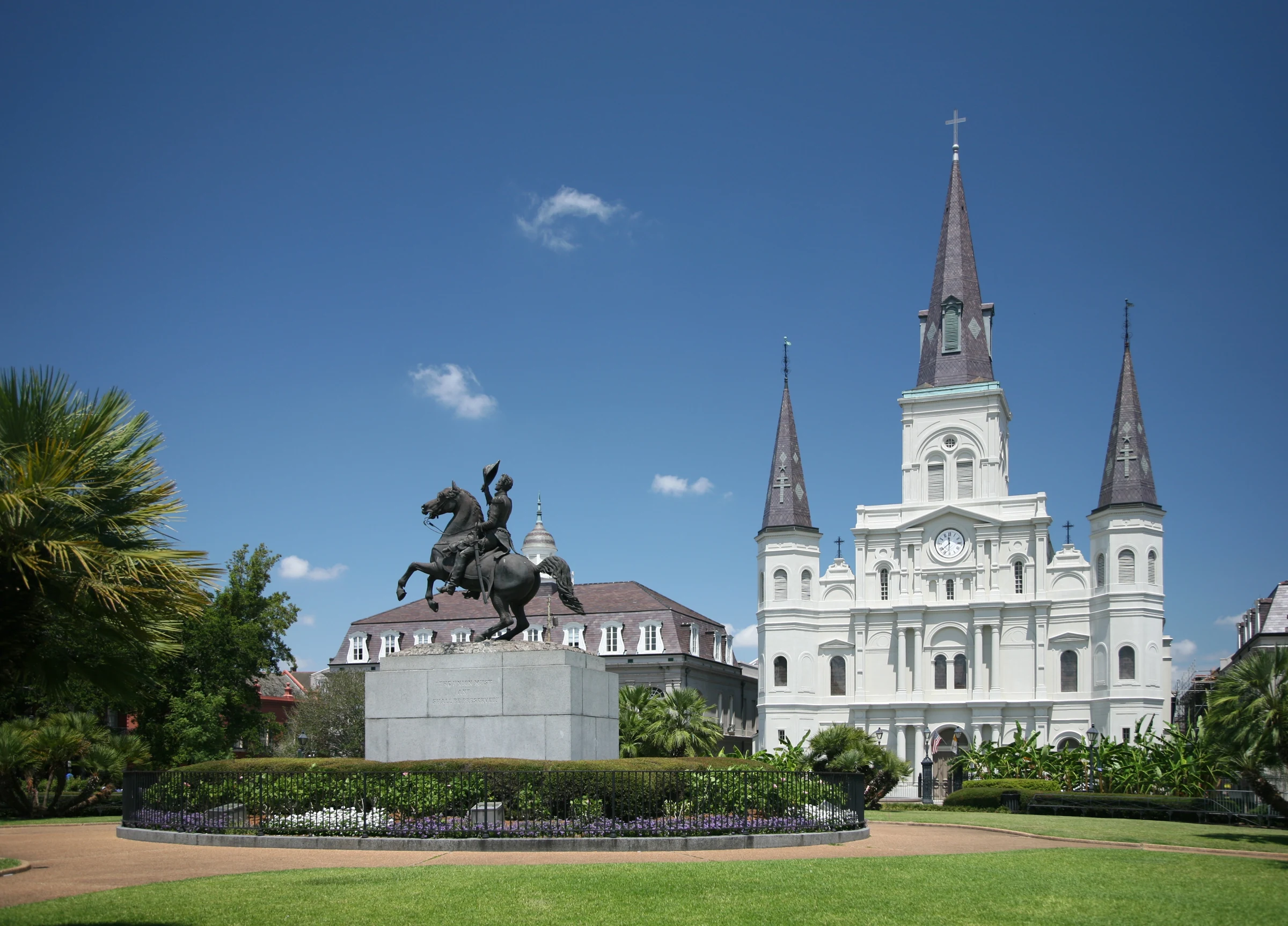 Jackson Square in New Orleans with the equestrian statue, garden and St Louis Cathedral under a blue sky