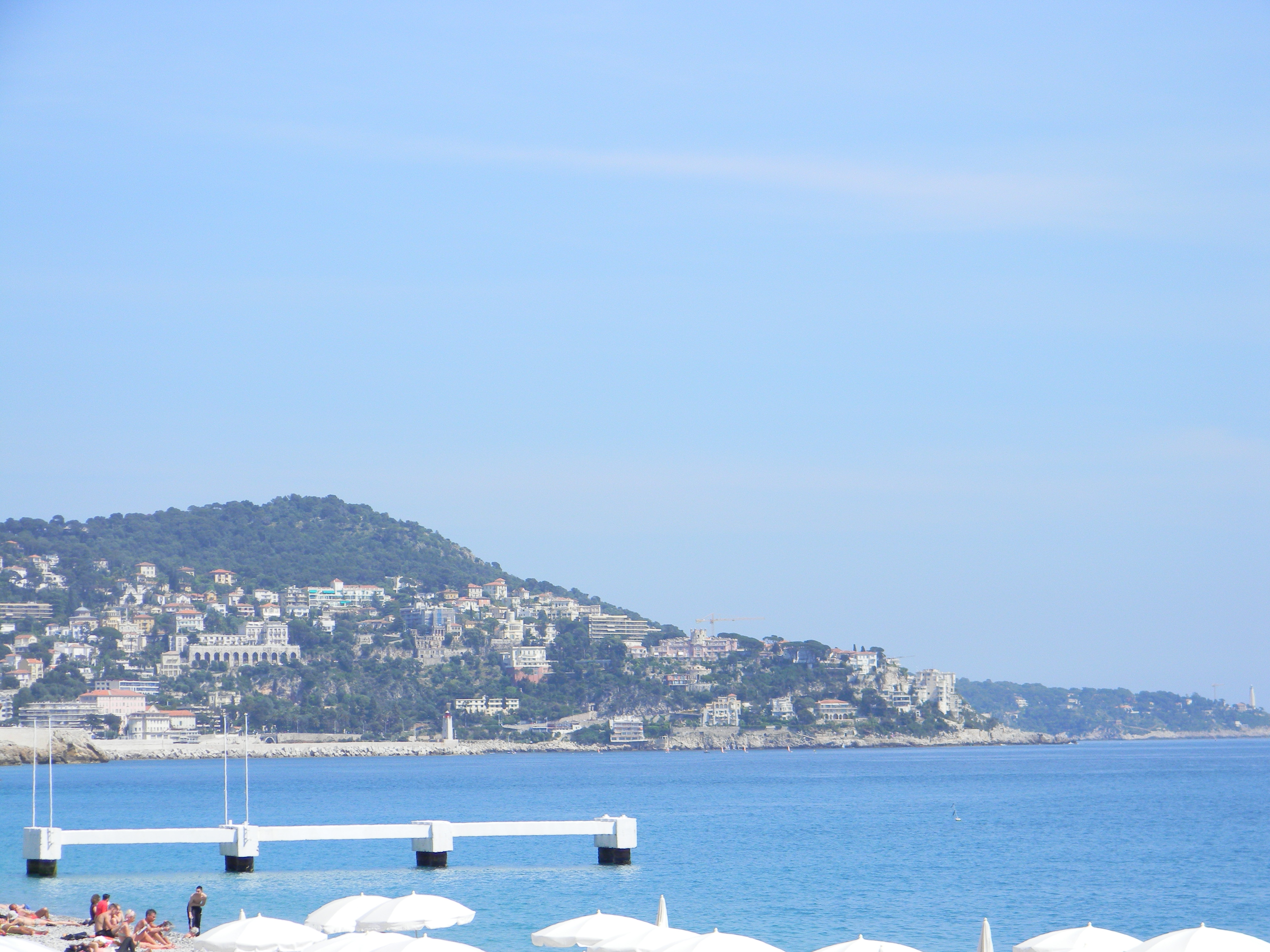 Nice waterfront and hillside buildings beyond the blue sea, seen from the Promenade side