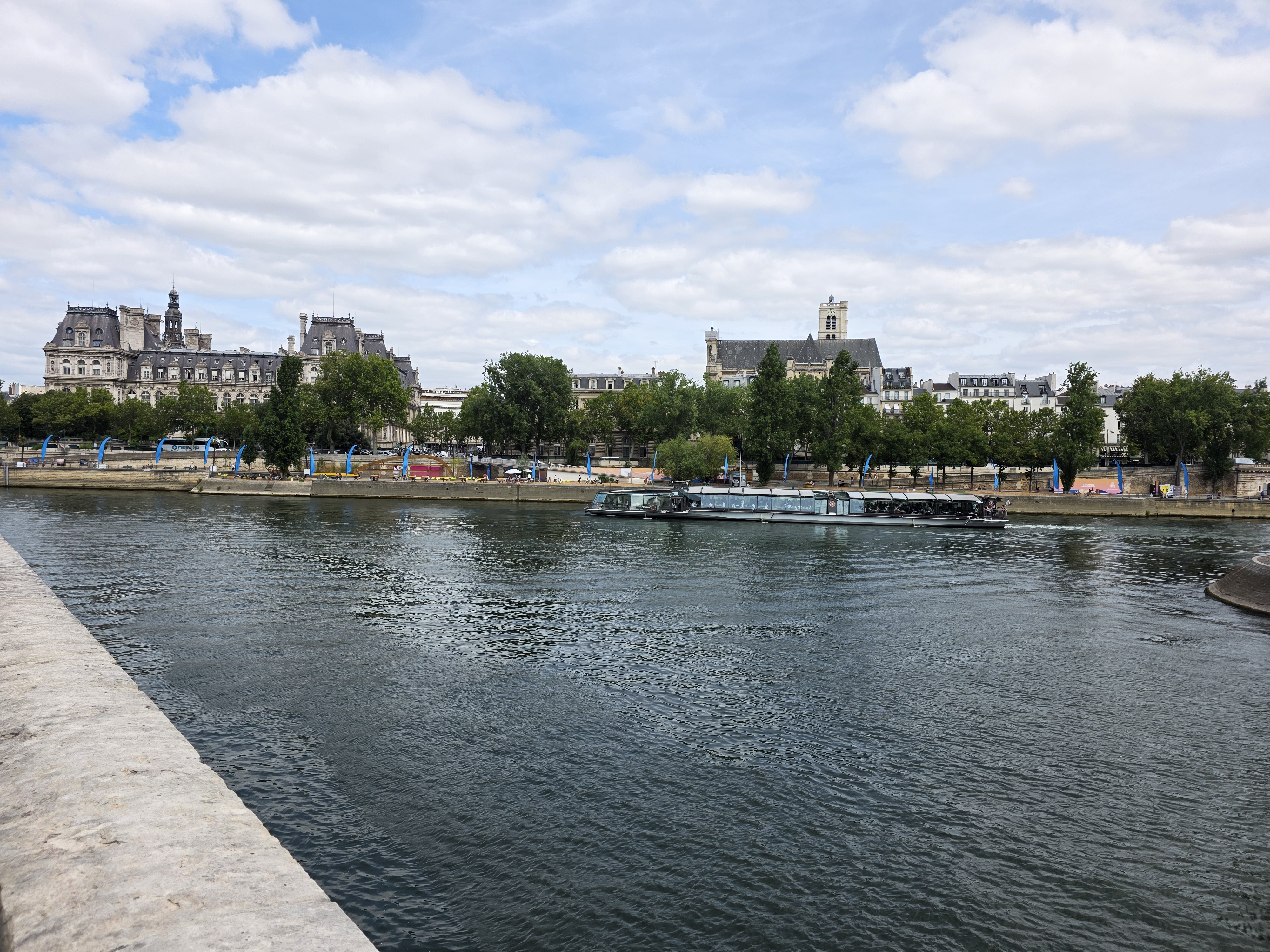 The Seine and riverside buildings near Pont Saint-Louis in Paris, with a sightseeing boat on the water